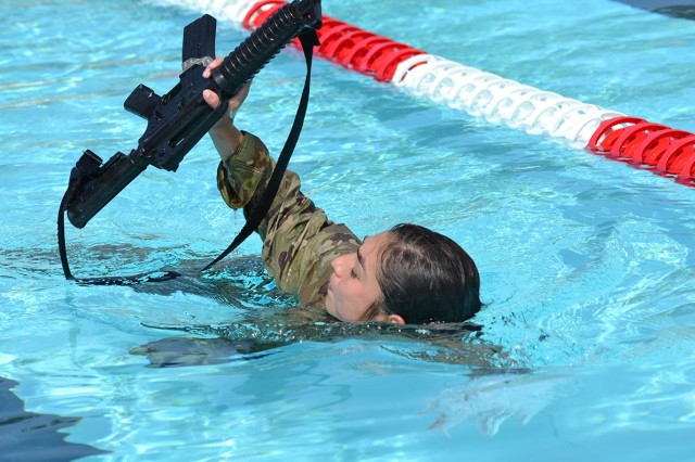 Spc. Vanessa Mundell swims 25 meters with an M4 carbine during the Army Combat Water Survival test portion of the Bayne-Jones Army Community Hospital Soldier and Noncommissioned Officer of the Year competition on April 15 at the Joint Readiness Training Center and Fort Polk. 
