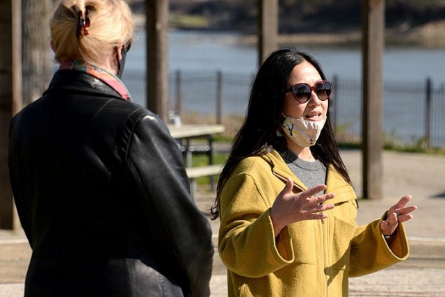 Leavenworth Mayor Nancy Bauder listens to "To Be At War" community photography project facilitator Arin Yoon's remarks during the opening of the open-air art exhibit featuring Yoon's portraits of service members and workshop participants'...