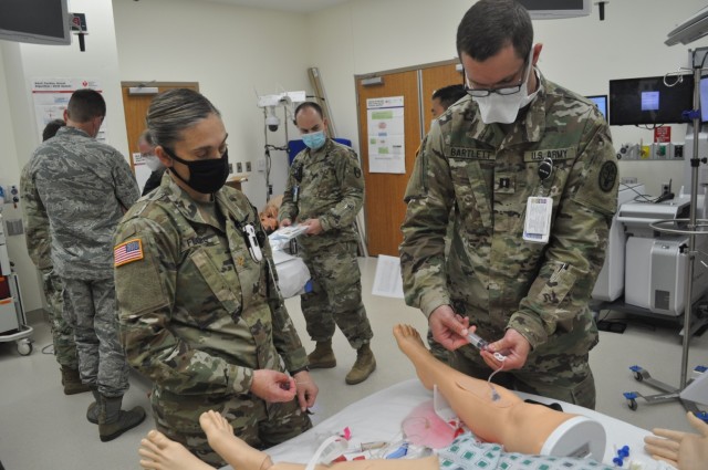 Martin Army Community Hospital 3rd-year residents Capt. S. Ivan Bartlett and Maj. Shelley Flores practiced intraosseous cannulation (IO) or drilling a sturdy needle through bone to infuse fluids and blood products to critically ill patients.