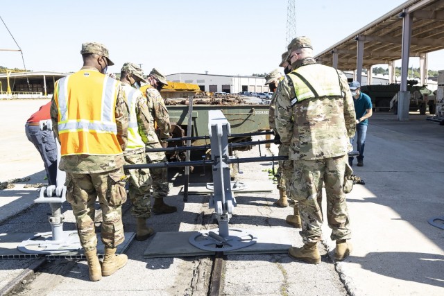 Soldiers from the 757th Expeditionary Rail Center configure the rear off-load platform for the RAIL system during a demonstration at Anniston Army Depot.