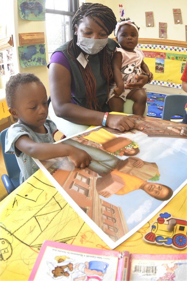 (Job_fair_photo3) Childcare provider Shauntell Briggs reads with toddlers Royalty Greene and Layla Lipsey at the Sisisky Child Development Center April 28. The CDCs and their parent organization, Child and Youth Services, has a number of job...