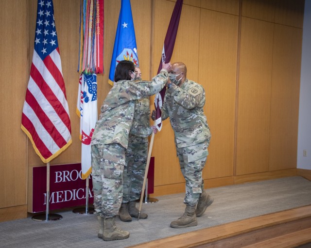 Army Brig. Gen. Shan K. Bagby, outgoing commanding general, passes the guidon to Army Brig. Gen. Wendy L. Harter, commanding general, U.S. Army Regional Health Command – Central, during a relinquishment of command ceremony at Brooke Army Medical Center, Fort Sam Houston, Texas, April 29, 2021. Bagby will succeed Harter as the RHC-C commanding general. (U.S. Army photo by Jason W. Edwards)