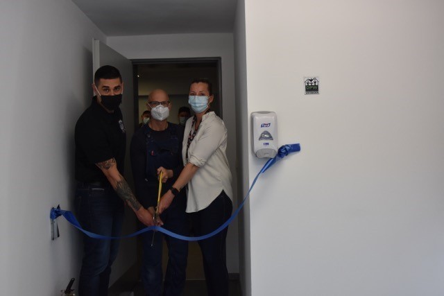 1st Sgt. Brian Vinci, Raymond Schaaf and Jasmin Taylor cut the ribbon for the newly renovated kitchen in building 1204.