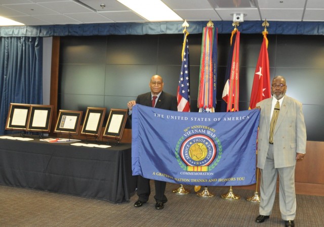 Vietnam veterans Burnie Coats, left, and David Lewis with the Vietnam War Commemoration flag following a Vietnam Veterans Commemoration program hosted by Army Materiel Command at Redstone Arsenal, Alabama.