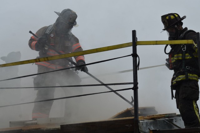 Brandon Duncan, Watertown Fire Department, opens up the roof of a burning structure to allow smoke to vent during the sixth annual Light and Fight training, hosted April 24 by Fort Campbell Fire and Emergency Services and the Fraternal Order of...