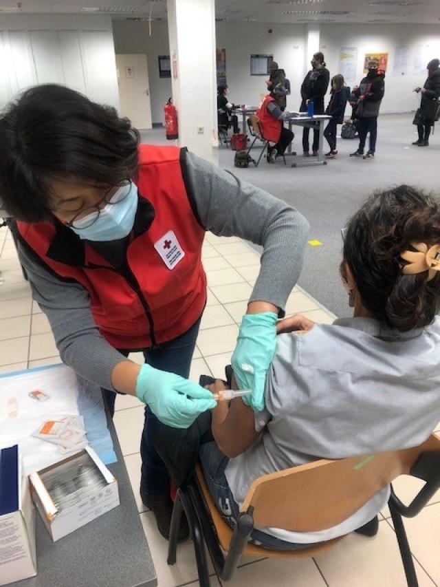 A Red Cross volunteers helps with vaccines for the community.