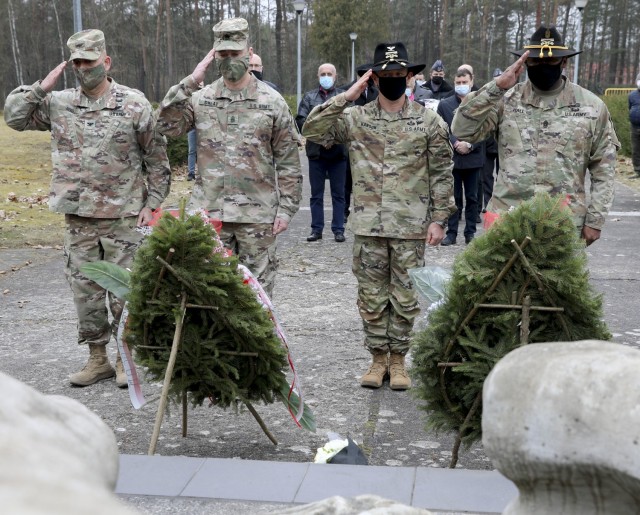 Colonel Ryan Hanson, commander 1st Armored Brigade Combat Team and Command Sergeant Major Calvin Hall, command sergeant major 1st Armored Brigade Combat Team salute alongside Colonel Ricardo Roig, commander 50th Regional Support Group and Command...