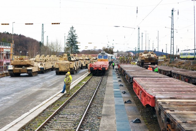 The scene at the railhead as U.S. Army Soldiers assigned to the 1st Armored Brigade Combat Team, 1st Cavalry Division, load armored vehicles in preparation for transfer to Poland, at Parburg, Germany, Mar. 13, 2021.