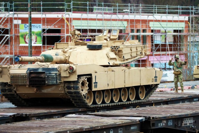 A U. S. Army Soldier assigned to the 1st Armored Brigade Combat Team, 1st Cavalry Division, guides an M1 Abrams Main Battle Tank onto a railcar in preparation for transfer to Poland, at Parsburg, Germany, Mar. 13, 2021.