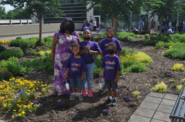 The Olszak family pose after planting purple flowers as part of Martin Army Community Hospital's Month of the Military Child celebration.