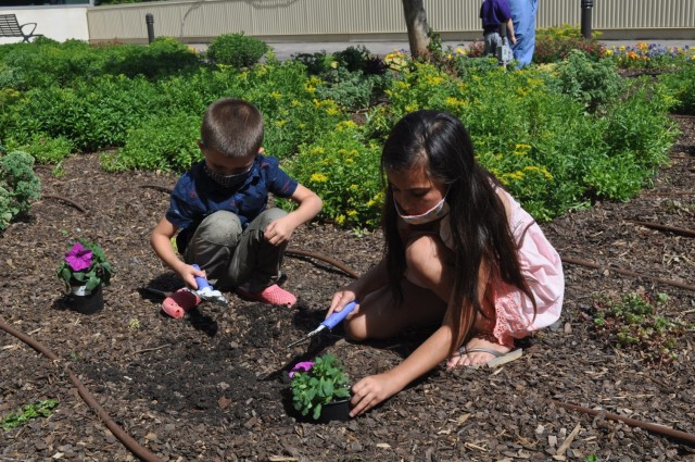 Nine-year-old Brooklyn McDaniel along with her younger brother Cameron plant purple flowers as part of Martin Army Community Hospital's Month of the Military Child celebration.