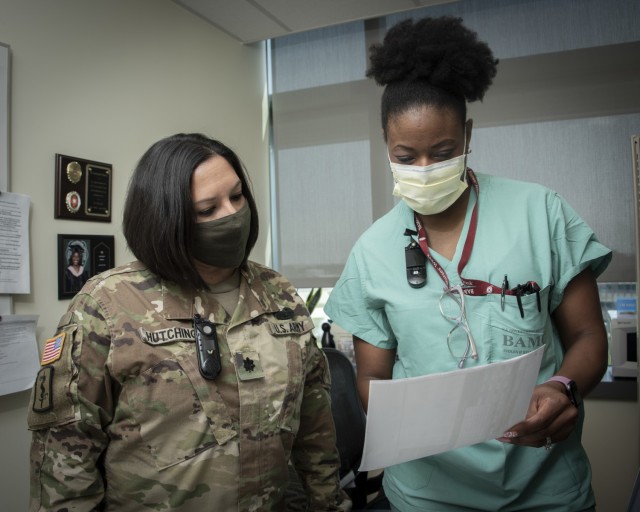 U.S. Army Lt. Col. DeAnna Hutchings, Chief, Critical Care Nursing Services, and Karriemah Munson, assistant clinical nurse officer in charge, 3T Medical Intensive Care Unit, review patient records at Brooke Army Medical Center, Fort Sam Houston, Texas, April 8, 2021. Hutchings was one of only 18 nurses from across the nation -- and the only military nurse -- to receive the 2021 Circle of Excellence award from the American Association of Critical-Care Nurses for care of acutely and critically ill patients and their families. (U.S. Army photo by Jason W. Edwards)