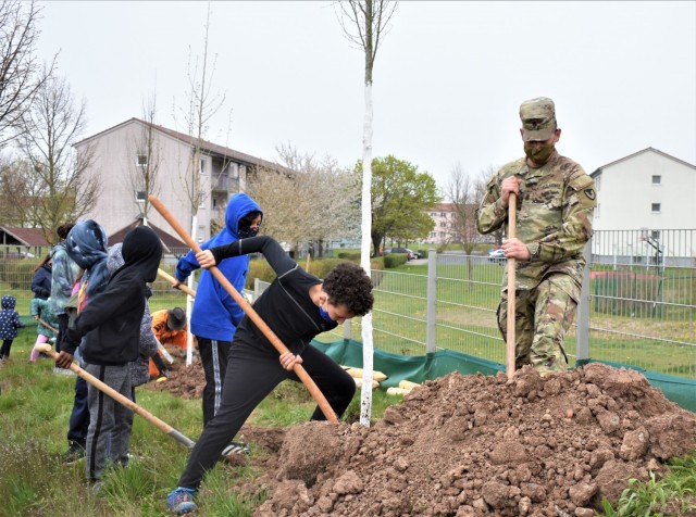 Command Sgt. Maj. Eric Bohannon lends a hand with planting trees at the CYS playground on Arbor Day, April 30, 2021.