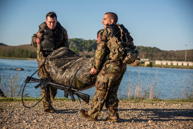 Capt. Manuel Ramirez and 1st Lt. Johnathan Trent carry their poncho raft May 1 after swimming across the lake at Training Area 250.