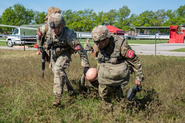 1st Lt. Eric Mattia and Staff Sgt. Martin Carreon extract a simulated casualty May 1 during the Care Under Fire lane of the Round Robin events on Gammon Field.