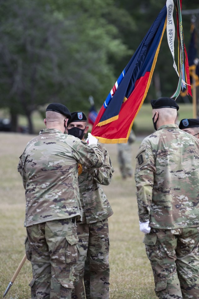 Command Sgt. Maj. Travis J. Wirth, senior enlisted leader for the 193rd Infantry Brigade, receives the unit colors from the brigade's commander Col. Mark Huhtanen during a change of responsibility ceremony May 3 at Victory Field. Wirth assumed...