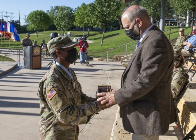 Dr. Ray Bateman, spouse of outgoing commander Brig. Gen. Wendy L. Harter, receives a gift during the Regional Health Command-Central change of command ceremony May 5 at Joint Base San Antonio-Fort Sam Houston.
