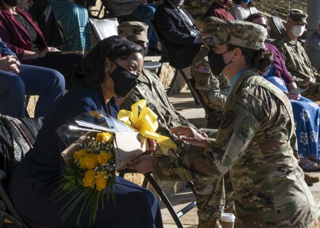 Melanie Bagby, spouse of incoming command Brig. Gen. Shan Bagby, accepts a bouquet of yellow roses during the Regional Health Command-Central change of command ceremony May 5 at Joint Base San Antonio-Fort Sam Houston.