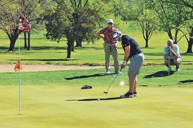 Burt Clark putts on Hole 9 as his teammates, from left, Cara Kendall and Gregg Daily look on Friday during the Commanding General’s Scramble at Piney Valley Golf Course.