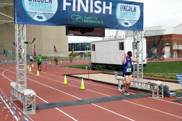 Lincoln, Neb. - Sgt. Nick Ledet, Company A, Recruiting and Retention Battalion, Kansas Army National Guard, points to the finish line in celebration as he completes the 2021 Lincoln Marathon in Lincoln, Nebraska May 2. Over the weekend, 181...