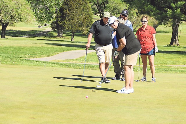A.J. Morris putts on Hole 18 Friday during the Commanding General’s Scramble at Piney Valley Golf Course. Looking on, from left, are her teammates Rick Morris, Freddy Brock and Debbie Kleinholz.