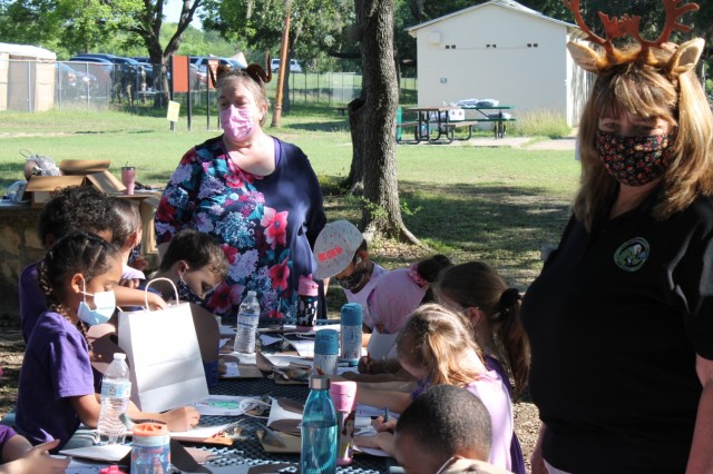 Terri Thomas (left), an environmental scientist, and Susan Elrod, a geologist, give the children an opportunity to participate in arts and crafts during the U.S. Army Environmental Command Nature Walk held for about 140 kindergarteners from the Fort Sam Houston Elementary School.