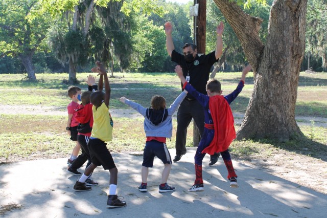 Damon Cardenas, a microbiologist, leads a group of children in jumping jacks at the U.S. Army Environmental Command Nature Walk held for about 140 kindergarteners from the Fort Sam Houston Elementary School.
