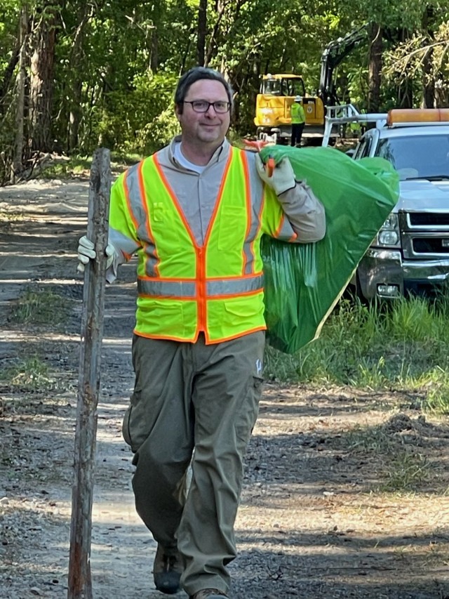 A volunteer carries debris during cleaning efforts as part of Fort Jackson&#39;s Earth Day.