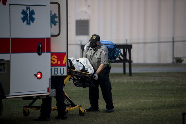 Benjamin Haigh, a paramedic with Emergency Medical Services, loads a notional casualty into the back of an ambulance at the conclusion of a heat casualty drill April 28 at the Noncommissioned Officer Academy on post.