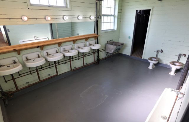 Having had combat boots scrape across them for nearly half a century, the visible wear on the steps demonstrates the many Soldiers who lived in the barracks. The latrine was also restored to its original condition.