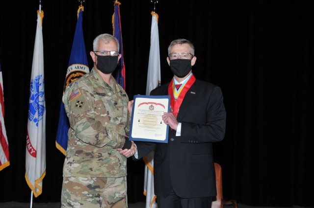 Col. Steven Carozza (left), Military Deputy Executive Director of the Integrated Logistics Support Center U.S. Army Tank-automotive and Armaments Command, inducts Timothy Goddette (right), outgoing Program Executive Officer, Combat Support and Combat Service Support, into the U.S. Ordnance Corps Association’s Order of Samuel Sharpe at Goddette’s Relinquishment of Leadership Ceremony at the Detroit Arsenal, Mich. May 4. 