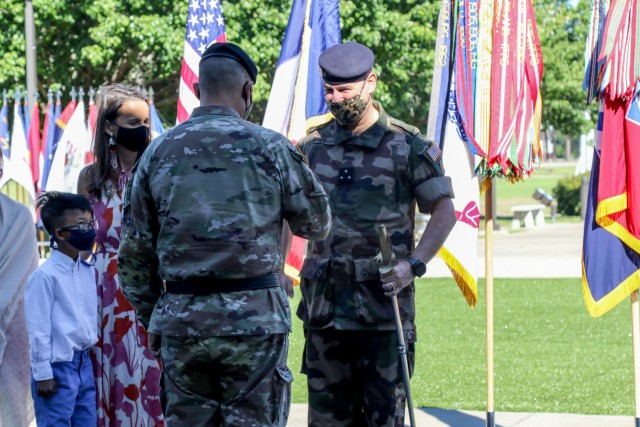 U.S. Army Maj. Gen. Antonio Aguto, commanding general of the 3rd Infantry Division, passes a cavalry saber to French Army Maj. Gen. Hubert Cottereau, deputy commanding general of the 3rd ID, to signify his warfighting ability during Cottereau’s...