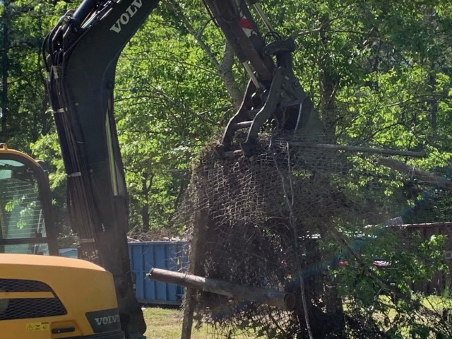 A backhoe removes fallen trees and other debris during Fort Jackson&#39;s Earth Day clean up efforts.