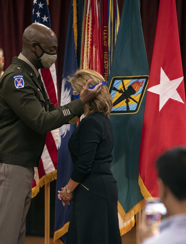 Fort Jackson Commander Brig. Gen. Milford H. 'Beags' Beagle Jr. places a ribbon around the neck of Madelyn Mercado during her induction into the Fort Jackson Hall of Fame April 22 at the NCO Club on post.