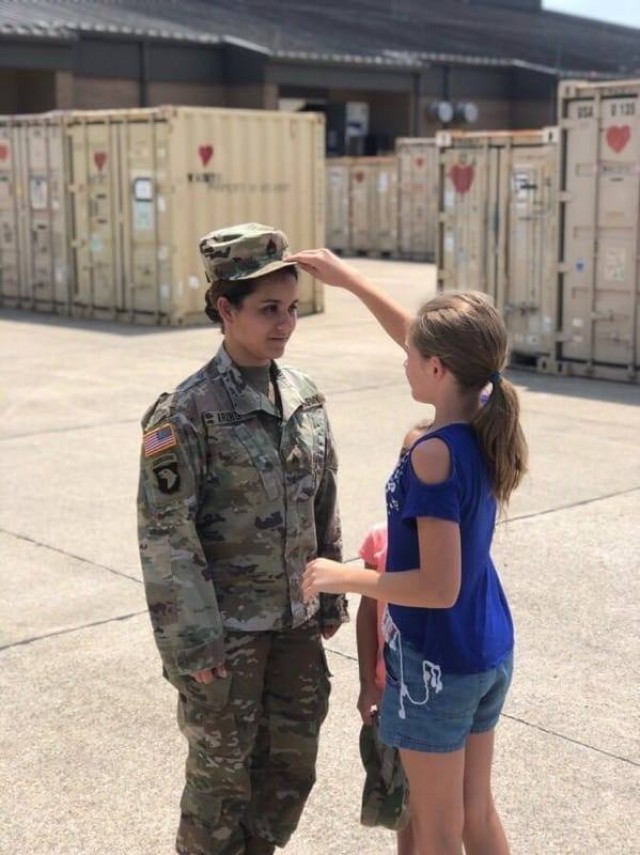 Staff Sgt. Christina Kring, recruiter, Catalina Recruiting Station, Tucson Recruiting Company, has the rank of staff sergeant pinned on her uniform by her stepdaughter Jailynn during a promotion ceremony, Aug. 1, 2019, Fort Campbell, Kentucky....