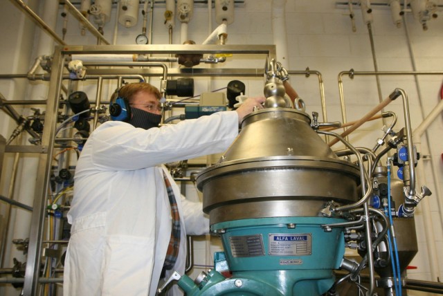 Joe Kragl, a Center biologist, operates a centrifuge in the extraction phase; it contains a bucket that functions like a large salad spinner, separating the microbes from the broth.