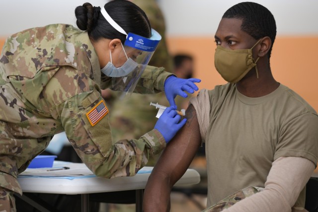 U.S. Army Spc. Eyza Carrasco, left, with 2nd Cavalry Regiment, administers a COVID-19 vaccination at the 7th Army Training Command's (7ATC) Rose Barracks, Vilseck, Germany, May 3, 2021. The U.S. Army Health Clinics at Grafenwoehr and Vilseck conducted a "One Community" COVID-19 vaccine drive May 3-7 to provide thousands of appointments to the 7ATC community of Soldiers, spouses, Department of the Army civilians, veterans and local nationals employed by the U.S. Army. 
(U.S. Army photo by Markus Rauchenberger)