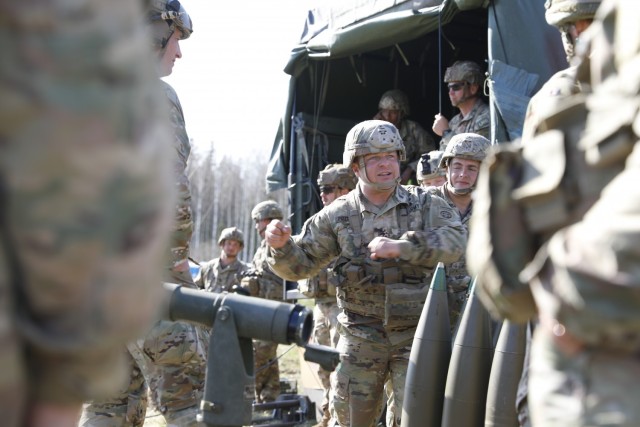 U.S. Army Sgt. 1st Class Ryan Pizzingrilli, assigned to Charlie Battery, 1st Battalion, 319th Airborne Field Artillery Regiment, 3rd Brigade Combat Team, 82nd Airborne Division, speaks with British Soldiers from the 7th Parachutes Regiment, Royal Horse Artillery about proper ammunition-handling techniques with the 155 mm shells at Tapa Central Training Area, Estonia, May 10, 2021. Swift Response 21 is a linked exercise of DEFENDER-Europe 21, which involves special operations activities, air assaults, and live fire exercises in Estonia, Bulgaria, and Romania, demonstrating airborne interoperability among NATO allies and partners. DEFENDER-Europe 21 is a large-scale U.S. Army-led exercise designed to build readiness and interoperability between the U.S., NATO allies and partner militaries. This year, more than 28,000 multinational forces from 26 nations will conduct nearly simultaneous operations across more than 30 training areas in more than a dozen countries from the Baltics to the strategically important Balkans and Black Sea Region. Follow the latest news and information about DEFENDER-Europe 21, visit www.EuropeAfrica.army.mil/DefenderEurope. (U.S. Army photo by Staff Sgt. Michael Gresso).