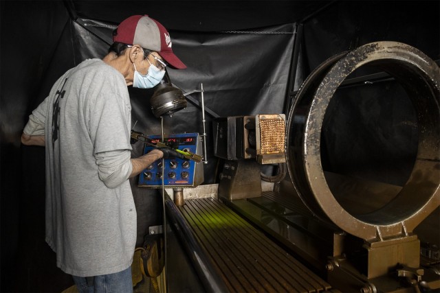 Doug Barksdale, a small arms repair technician, views a part under a black light in the Small Arms Repair Facility. Prior to obtaining the borescope, technicians could only check for cracks on the outside of parts using non-destructive particle...