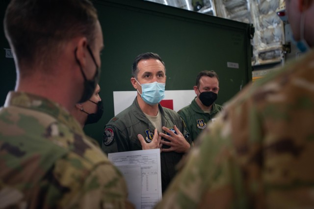 Maj. Kenneth Strunk, 446th Airlift Wing, receives patient manifest updates from Capt. Christine Newby, 349th Aeromedical Evacuation Squadron, prior to departing Travis Air Force Base, California, aboard a C-17 Globemaster III on April 27, 2021. Both are participating in Exercise Nexus Dawn, which presents realistic and challenging combat readiness scenarios in which Reserve Citizen Airmen are tested and evaluated at how well they can execute their mission. (U.S. Air Force photo by Dennis Santarinala)