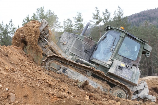 A U.S. Army Soldier assigned to the 2nd Cavalry Regiment digs dirt using an armored bulldozer during Dragoon Ready 21 at the Hohenfels Training Area, April 17, 2021. Daily training, conducted in realistic environments, under realistic circumstances, ensures our forces maintain the highest levels of proficiency and readiness for worldwide deployment. (U.S. Army photo by Sgt. Julian Padua)