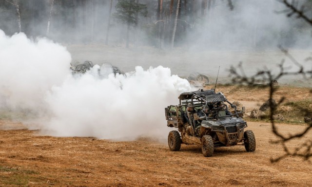 Members of the opposing forces team from 1st Battalion, 4th Infantry Regiment deploy smoke from the back of their all-terrain vehicle during the Dragoon Ready 21 training exercise at Hohenfels Training Area, Germany, April 19, 2021. Dragoon Ready 21 is a 7th Army Training Command-led exercise conducted in HTA, Germany. (U.S. Army photo by Master Sgt. Ryan C. Matson)