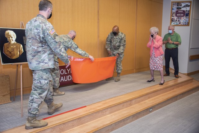 Brig. Gen. Shan K. Bagby, U.S. Army Regional Health Command – Central commanding general, and Col. Michael Wirt, Brooke Army Medical Center commander, unveil the sign for the newly dedicated “Carolyn D. Putnam Auditorium” while Sgt. Major, Gabriel R. Wright, chief clinical noncommissioned officer, Carolyn Putnam, secretary to the commander, and her son, Chip Putnam, look on during a Virtual Legacy of Service Ceremony at BAMC, Fort Sam Houston, Texas, May 11, 2021. The dedication in her name was a surprise to Putnam, who has been in federal civil service for 66 years, 61 of which have been at BAMC. (U.S. Army photo by Jason W. Edwards)