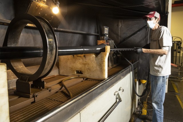 Doug Barksdale, a small arms repair technician, inserts a video borescope into an 81mm mortar gun tube in the Small Arms Repair Facility. The borescope allows technicians to inspect the inside of a gun tube for cracks.