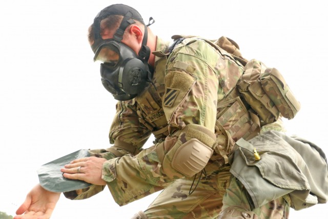U.S. Army Sgt. Hunter Davidson, an infantryman assigned to 3rd Battalion, 15th Infantry Regiment, 2nd Armored Brigade Combat Team, 3rd Infantry Division, simulates decontaminating his skin during the Division’s Soldier and Noncommissioned...