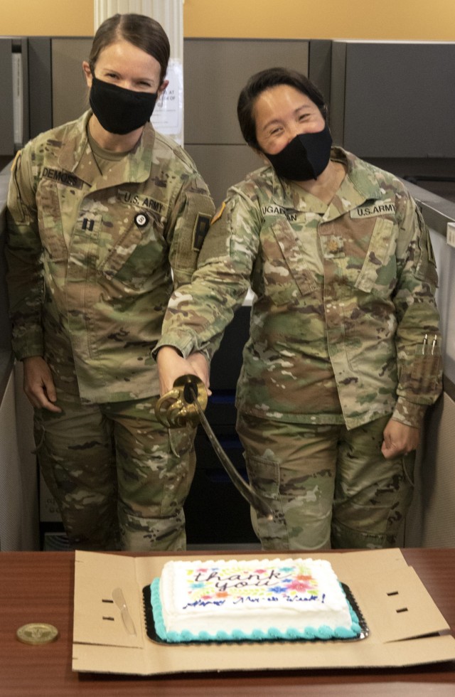 Maj. Mary Ugaddan (right) joins Capt. Erin DeMoss to celebrate Nurses Week with a cake cutting in the First Army Command Surgeons office.