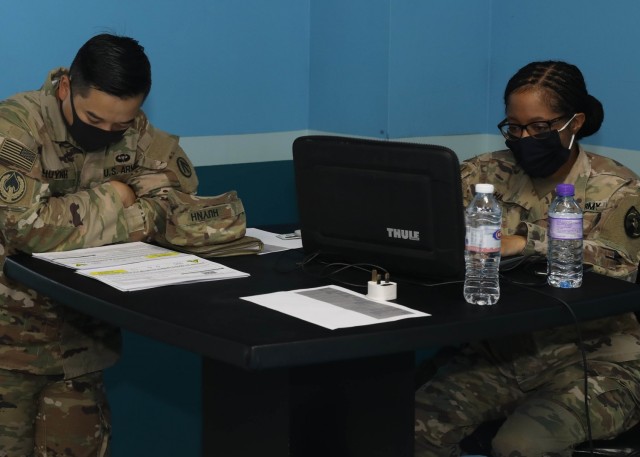 Army Sgt. 1st Class Dat Huynh, deployed to Camp Arifjan, Kuwait, with the 595th Transportation Brigade (SDDC), reviews the data related to the COVID-19 vaccinations offered May 5, 2021 as part of the restart of vaccine administration in theater by the 3rd Medical Command (Deployment Support).  The 3rd MCDS &#34;Desert Medics&#34; coordinate the COVID-19 response throughout the U.S. Central Command area of operations. (U.S. Army photo by Staff Sgt. Neil W. McCabe)