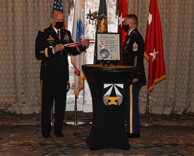 U.S. Army Maj. Gen. Ross Coffman, director of the Next Generation Combat Vehicle Cross-Functional Team, presents The Order of Saint George Silver Medallion to Command Sgt. Maj. Paul Biggs during his retirement ceremony at Joint Base Langley-Eustis, Virginia, May 13, 2021. The Silver Medallion of the Order of Saint George recognizes Brigade Command Teams of any combat arms or combat support branch and senior Armor and Cavalry officers and NCOs as well as their Foreign Armor and Cavalry counterparts who successfully served for twenty or more years. Biggs retired after serving more than 33 years in various levels of leadership to include his last position as the Futures and Concepts Center command sergeant major. (U.S. Army photo by David Miller)