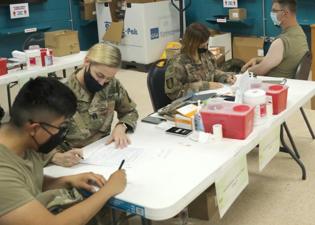 Soldiers deployed to Camp Arifjan, Kuwait, May 5, 2021 fill out their vaccination cards and paperwork before receiving the COVID-19 vaccination during the restart vaccine administration by 3rd Medical Command (Deployment Support). The &#34;Desert...