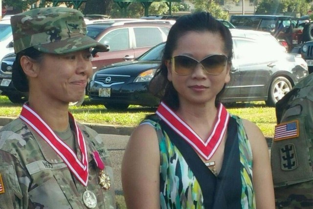 Army Col. Danielle Ngo, left, stands with her sister, Lan-Dinh Ngo, after relinquishing command of the 130th Engineer Brigade at Schofield Barracks, Hawaii, July 10, 2018.